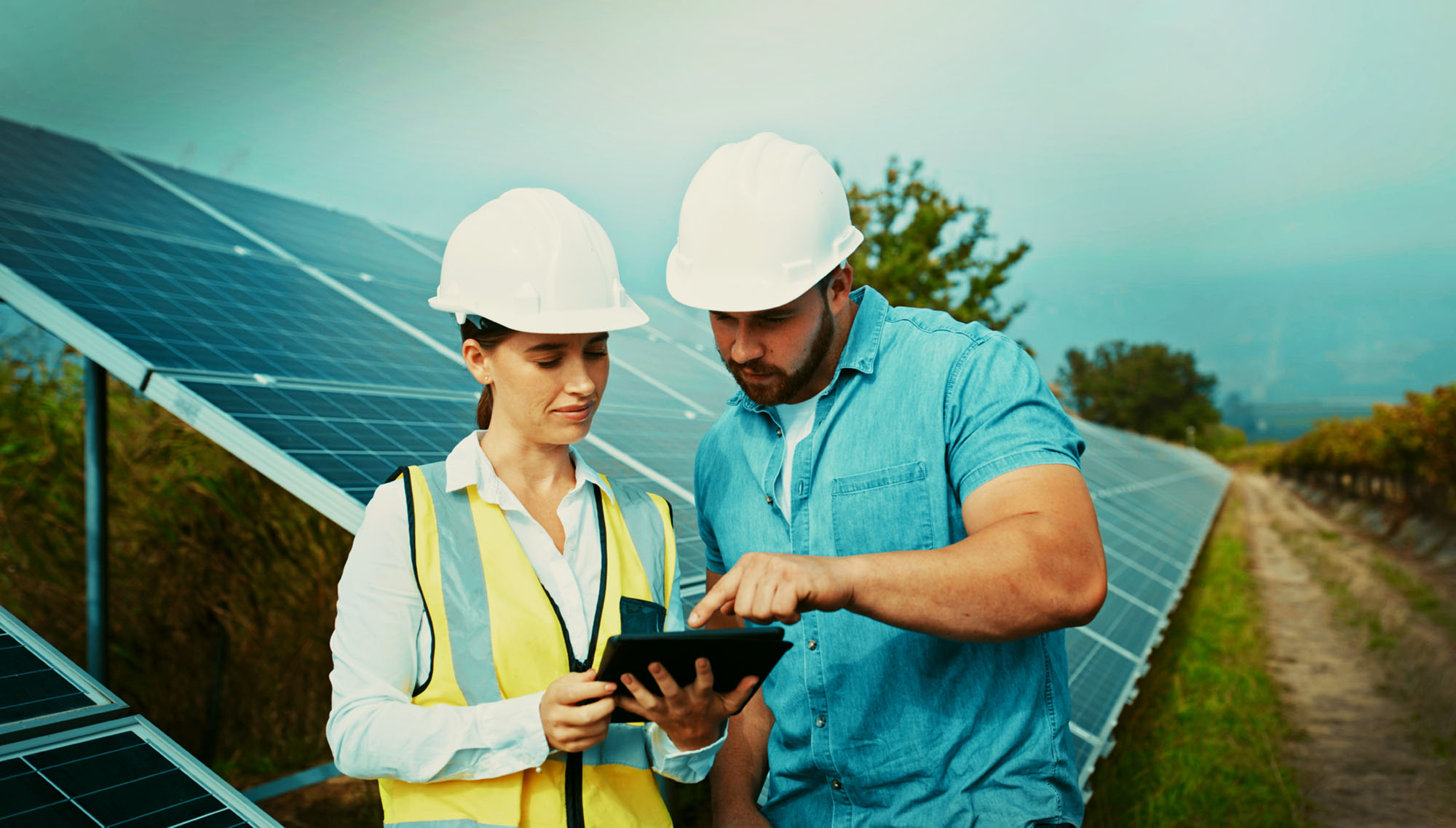 Construction workers standing in front of solar panels at a PureSky solar farm during the construction phase.